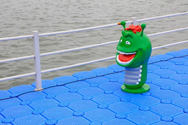 Şamandıradaki yeşil böceklerin plastik heykelleri.