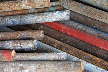 Oksitlenmiş paslı çelik borular üst üste yığılmış.