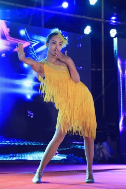 Tangshan City - 16 Haziran 2016: Sarı elbiseli kadın sahnede şarkı söylüyor, Tangshan City, Hebei, Chin