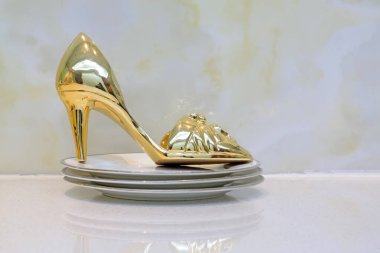 Yüksek topuklu ayakkabıyı seramik tabakta yeniden düzenle.