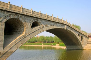 Su parkındaki antik taş köprü, fotoğrafa yakın çekim.