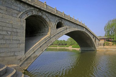 Su parkındaki antik taş köprü, fotoğrafa yakın çekim.