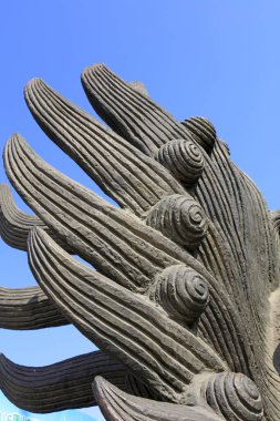 Mavi gökyüzüne karşı desenli taş heykelin ayrıntılı yakın çekimi