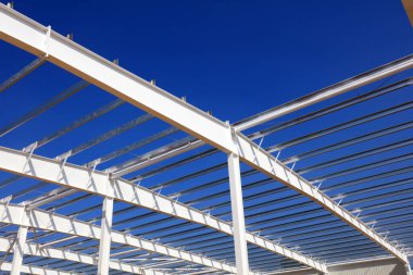 Mavi gökyüzünün altında beyaz bir çelik kiriş