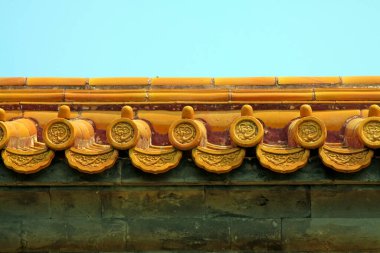 Açık mavi gökyüzü arkaplanına karşı süslü çatı kiremitleri