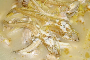 Kremalı çorba içinde yüzen balık parçaları.