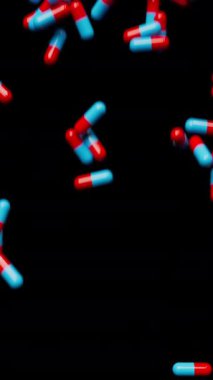 Mavi ve kırmızı haplar yere düşer ve ekran alanını doldurur. İlaç kapsülleri arka plan. Eczacılık konsepti. 3D canlandırma canlandırması. dikey video.