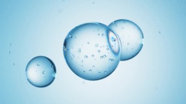 Üç damla mavi sıvı, içinde kabarcıklar olan bir sıvıya dönüşür. Deri bakım serumu damlacıkları bir araya geliyor. Kozmetik nemlendirici sıvı konsepti.