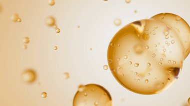 Üç damla bej sıvıdan oluşan makro, içinde kabarcıklar olan bir taneye dönüşür. Deri bakım serumu damlacıkları bir araya geliyor. Kozmetik nemlendirici sıvı konsepti.