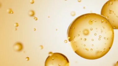 Üç damla sarı sıvı makro içinde kabarcıklar olan bir taneye dönüşür. Deri bakım serumu damlacıkları bir araya geliyor. Kozmetik nemlendirici sıvı konsepti.
