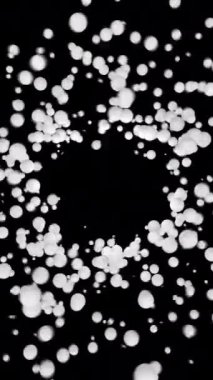 Parçacıklar merkezi boş deliğe çekerler ve etrafında dönerler. Logo için boş alandaki kürelerin girdap hareketi. Beyaz top döner ve saydam bir arkaplanda zıplar. Dikey video.