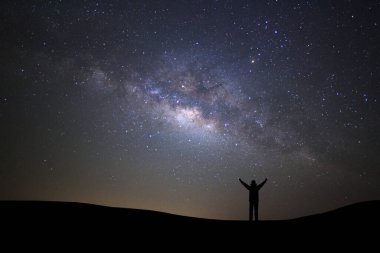 Yatay, Samanyolu, yıldızlı gece gökyüzü yıldız ve yüksek dağ kadar yükseltilmiş kollarda ayakta sportif adamla silüeti.