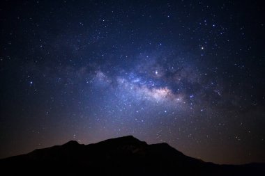 Yüksek dağların üzerinde Samanyolu galaksisiyle manzara yıldızlı gece gökyüzü.