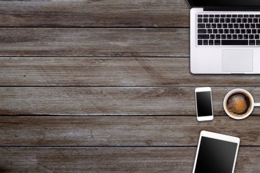 Laptop tableti, akıllı telefon ve kahve fincanı olan modern çalışma alanı ahşap arka planda. Üst Manzara. Düzleştirme biçimi.