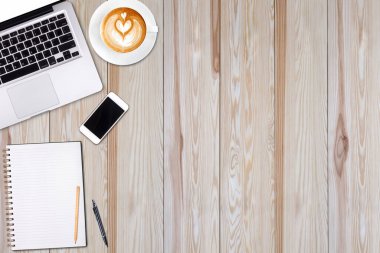 Üstten Görünüm dizüstü bilgisayar ya da dizüstü bilgisayar, cep telefonu ve latte sanat üzerinde ahşap masa kahve fincan. İş Şablon metninizi ekleme için sahte