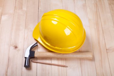 Çekiç, kalem ve sarı şapka ahşap sırtüstü