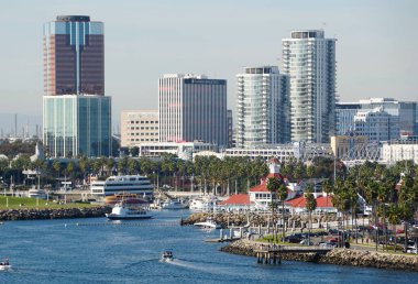 Long Beach, California, ABD - 5 Kasım 2022 - Güneşli bir günde Queensway Körfezi boyunca bulunan tekne limanı ve binaların manzarası