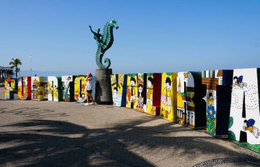 Puerto Vallarta, Meksika - 9 Kasım 2022 Turistlerle dolu renkli ve popüler şehir tabelasının yan görüntüsü