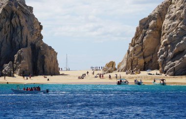 Cabo San Lucas, Meksika - 7 Kasım 2022 - Kalabalık Aşıklar Sahili ve kaya oluşumu yakınlarındaki ziyaretçiler ve tekneler