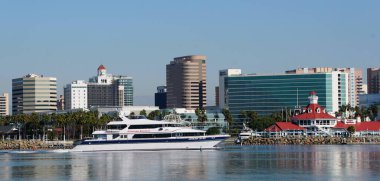 Long Beach, Kaliforniya, ABD - 12 Kasım 2022 - Güneşli bir günde Queensway Körfezi boyunca uzanan şehrin arka planına sahip Catalina Ekspres Teknesi