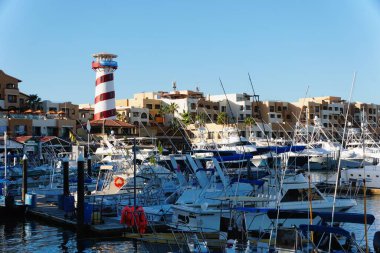 Cabo San Lucas, Meksika - 7 Kasım 2022 Sıcak güneşli bir günde tekne marinası ve tekila deniz feneri manzarası