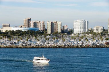 Long Beach, California, ABD - 5 Kasım 2022 - Güneşli bir günde Queensway Körfezi boyunca bulunan yat marinası ve binaların manzarası