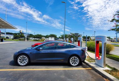 Rehoboth Beach, Delaware, ABD - 30 Temmuz 2022 - Şarj istasyonunda koyu mavi bir Tesla Model 3 sedan