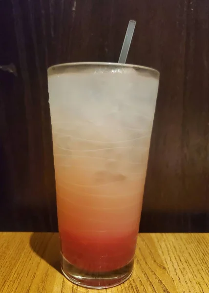 草莓粉柠檬水加冰块和稻草在塑料杯里 — 图库照片