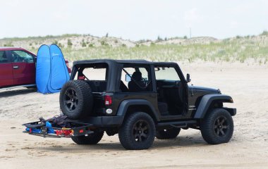 Fenwick Adası, Delaware, ABD - 8 Temmuz 2023 - Kuma park edilmiş sörf balıkçı plajı izni olan siyah bir Jeep Wrangler