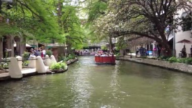 San Antonio, Teksas, ABD - 6 Nisan 2024 - Houston Caddesi köprüsünün altından geçen ziyaretçileri taşıyan Go Rio Nehri Teknesi turunun kırmızı rengi