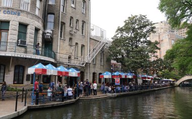 San Antonio, Teksas, ABD - 6 Nisan 2024 Nehir yürüyüşü boyunca restoranın masalarında oturan ziyaretçiler