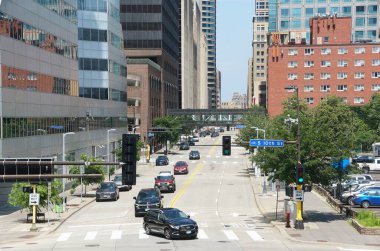 Minneapolis, Minnesota, ABD - 12 Temmuz 2024 - Güneşli bir günde S 10. caddedeki trafik, Skyway köprüsü ve modern binaların manzarası