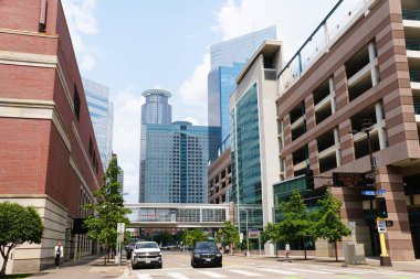 Minneapolis, Minnesota, ABD - 9 Temmuz 2024 - Güneşli bir günde yüksek binalar, Skyway köprüsü, oteller ve S 11. caddedeki trafik