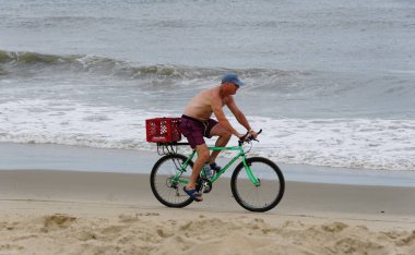 Lewes, Delaware, ABD - 4 Temmuz 2024 Sahilde bisikletli bir adam