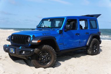 Rehoboth Beach, Delaware, ABD - 15 Eylül 2024 - yepyeni 2024 Jeep Wrangler 4XE Willys hibriti açık hava sahili üzerine park edilmiş mavi renkli