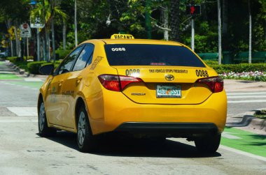Key Biscayne, Florida, ABD - 20 Eylül 2024 Toyota Corolla sarı bir taksiye dönüştü.