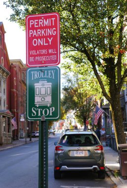 Jim Thorpe, Pennsylvania, U.S.A - October 19, 2024 - The trolley stop and permit parking alert sign on Broadway Street clipart