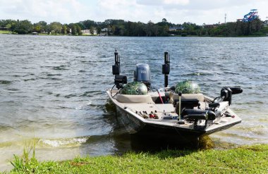 Winter Haven, Florida, U.S.A - Nov 14, 2024 - A fishing boat rests gently on the water's edge, ready for the day's catch. clipart