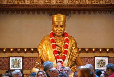 Robbinsville, New Jersey, U.S.A - November 9, 2024 - The golden statue of the Holiness Mahant Swami Maharaj inside of the visitor center clipart