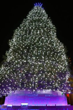 Philadelphia, Pennsylvania, ABD - 30 Aralık 2024 - Üsteki binlerce parıldayan ışık ve mor sanat sergisi ile süslenmiş muhteşem bir Noel ağacı