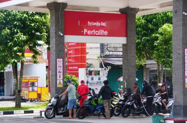Bali, Endonezya - 27 Ocak 2025 - Kalabalık bir Pertamina benzin istasyonu sahnesi, çeşitli motosikletleri ve yakıt ikmali yapan insanları gösteriyor.