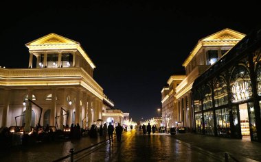 Doha, Katar - 18 Ocak 2025 - Gece sahnesi ve binalar Katara Köyü 'ndeki Dükkanlar tarafından aydınlatıldı