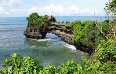 Endonezya 'nın Bali adasının kayalık oluşumu ve yemyeşil yeşilliği antik Hindu hac tapınağı Pura Tanah Lot' a ev sahipliği yapıyor..