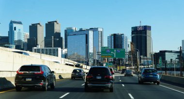 Philadelphia, Pennsylvania, ABD - 10 Mart 2025 Schuylkill Otoyolu boyunca açık bir gökyüzü altında, seçkin şehir binalarıyla trafik ilerliyor..