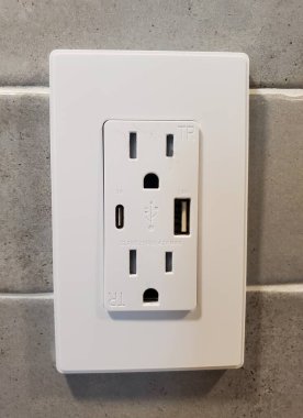 Lewes, Delaware, ABD - 2 Mart 2025 - USB ve C tipi portların kullanışlı şarj edildiği parlak beyaz bir priz.