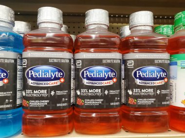 Wilmington, Delaware, ABD - 5 Mart 2025 - Kırmızı sıvı Pedialyte şişeleri sergilenen Soğuk Kiraz Nar aromaları.