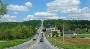 Quarryville, Pennsylvania, ABD - 7 Mayıs 2025 Lancaster Pike 'daki güneşli gökyüzü ve yemyeşil bir şehir manzarası