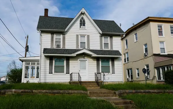 Avondale, Pennsylvania, ABD - 7 Mayıs 2025 Klasik, iki katlı, ön verandalı ve iyi bakılmış çimenliği olan bir ev.