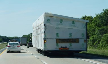 Middletown, Delaware, ABD - 21 Mayıs 2025 - Prefabrik bir ev, koruyucu çarşafa sarılı, büyük bir römorkla taşınıyor.
