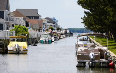 Okyanus Şehri, Maryland, ABD - 21 Mayıs 2025 - Kanal boyunca Assawoman Körfezi 'ne demirlemiş çeşitli tekneleri gösteren sakin bir su yolu